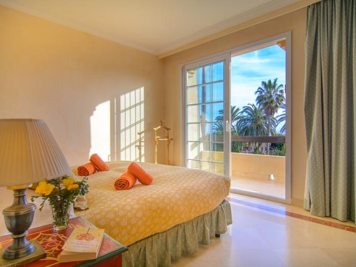 Guest bedroom with large door opening to balcony