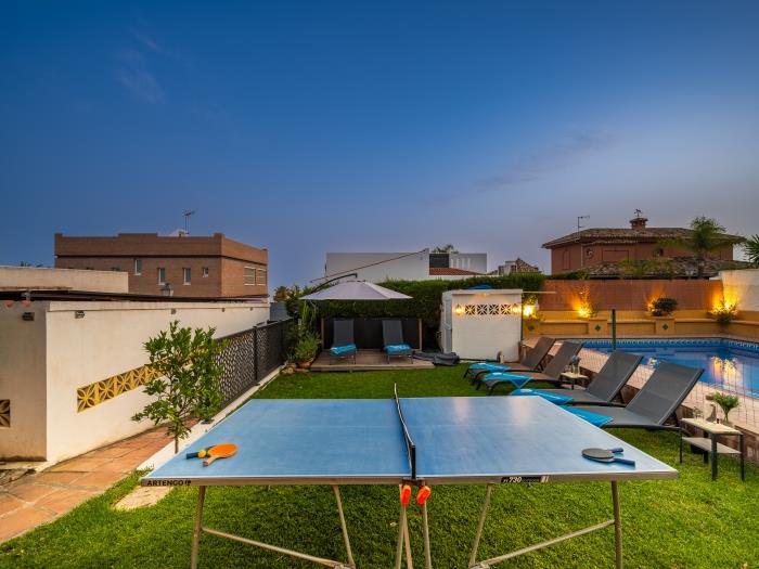 Ping-pong table and a lounge area with sun loungers and an umbrella