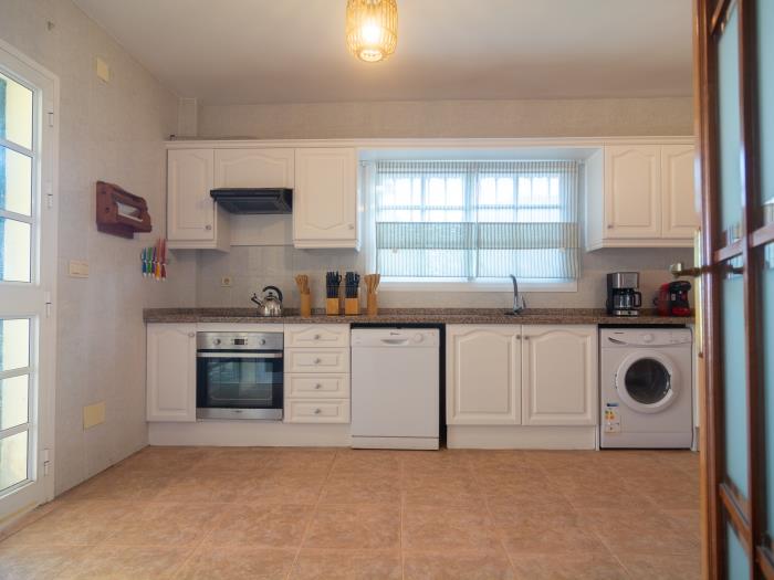 A fully equipped kitchen with utility room