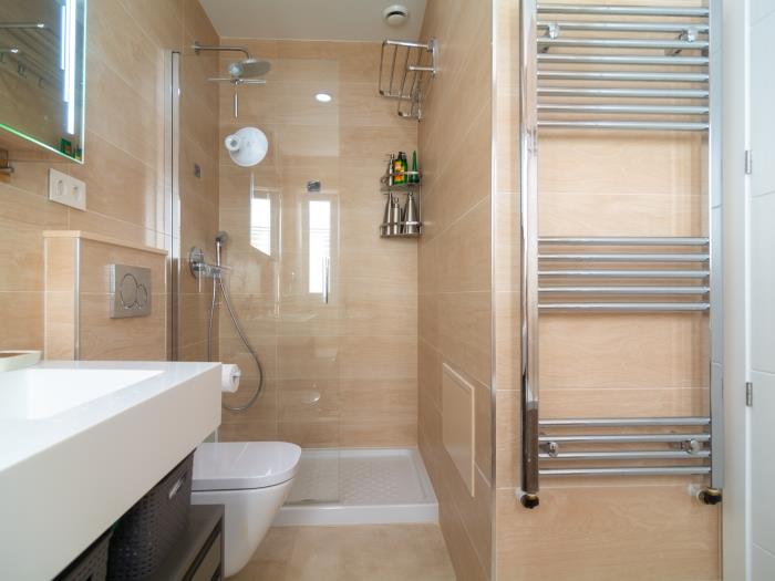 En suite bathroom has a double sink, bathtub, walk-in shower with rain head, toilet