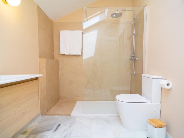En suite bathroom with walk-in shower, toilet, double sink in pastel colors