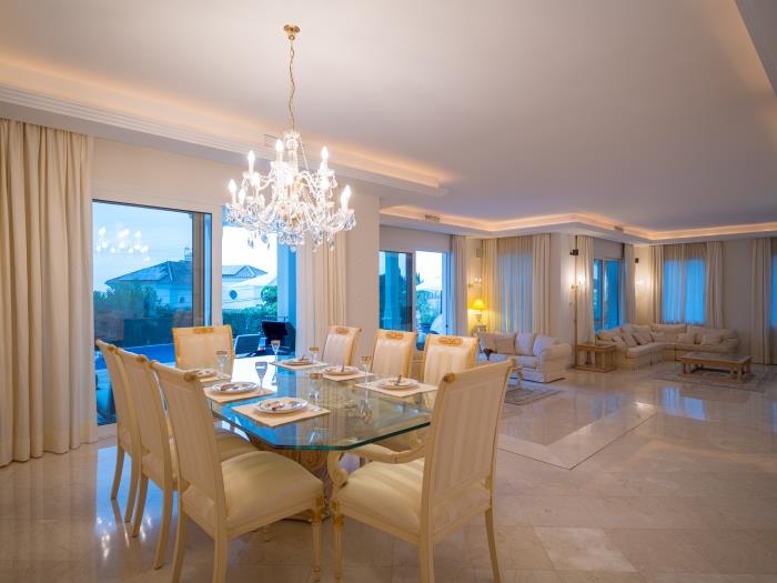 Dining area with glass table for 8 with elegant cristal chandeliers