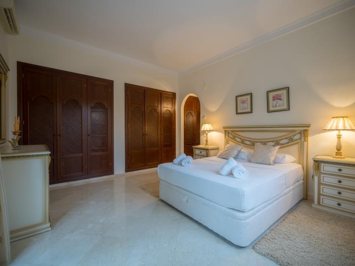 Double bed, nightstands with lamps, recessed wardrobes in the bedroom on the ground level