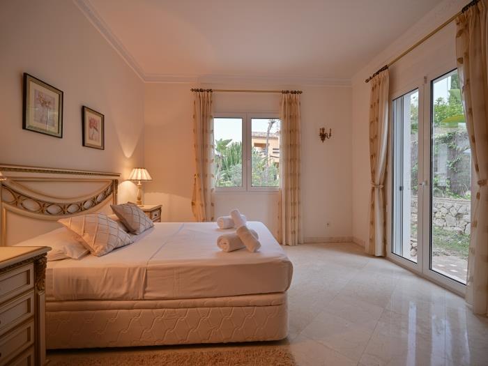 Double bed and garden views in bedroom with marble floors and air conditioners