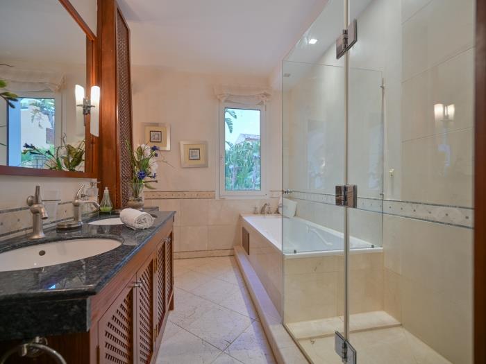 Bathroom with bathtub, walk in shower, double sink and garden views