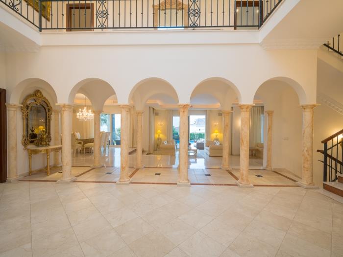 Columns with arches, marble floors and distinguished furniture in living room