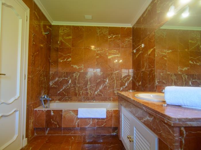 En suite bathroom with bathtub with shower, sink, bidet and toilet
