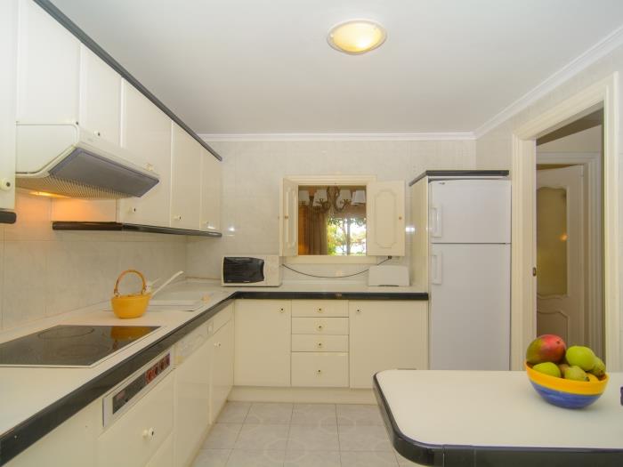 Fully equipped kitchen with a small window that opens to the dining area