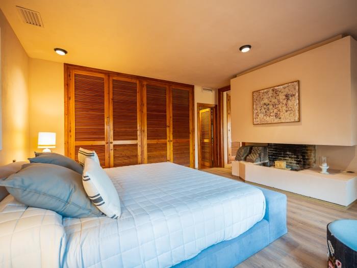 Master bedroom with recessed wardrobes, king size bed and beautiful artworks