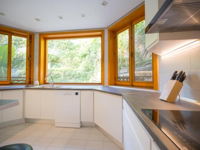 Fully equipped kitchen with three large windows that allow light to invade