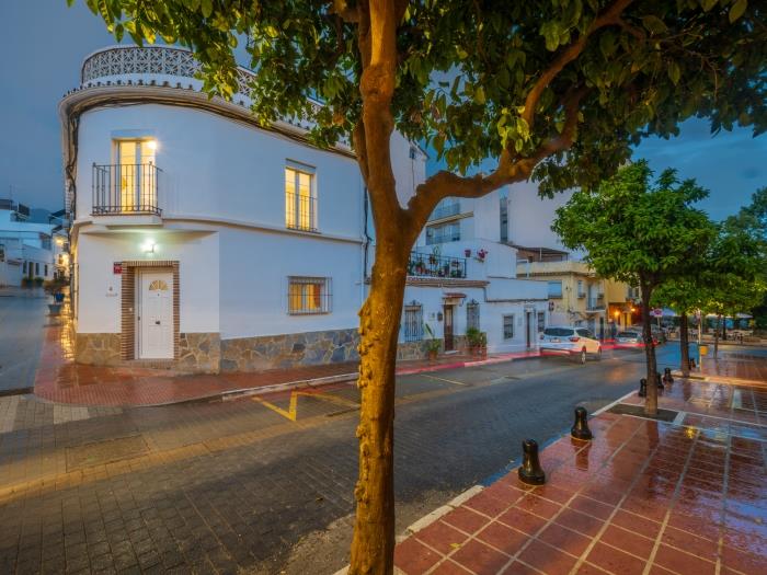 Modern accommodation in the old town of Marbella with cobblestone streets with orange trees