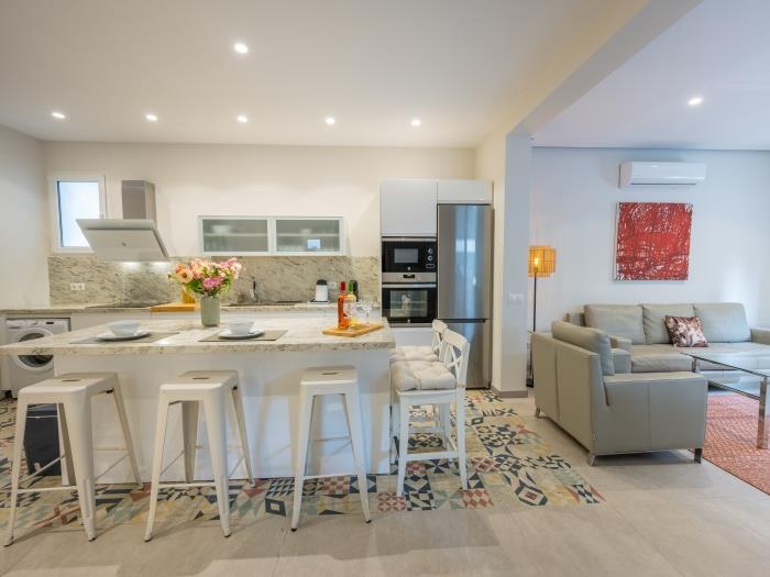 Open-plan kitchen with modern appliances and island with bar stools