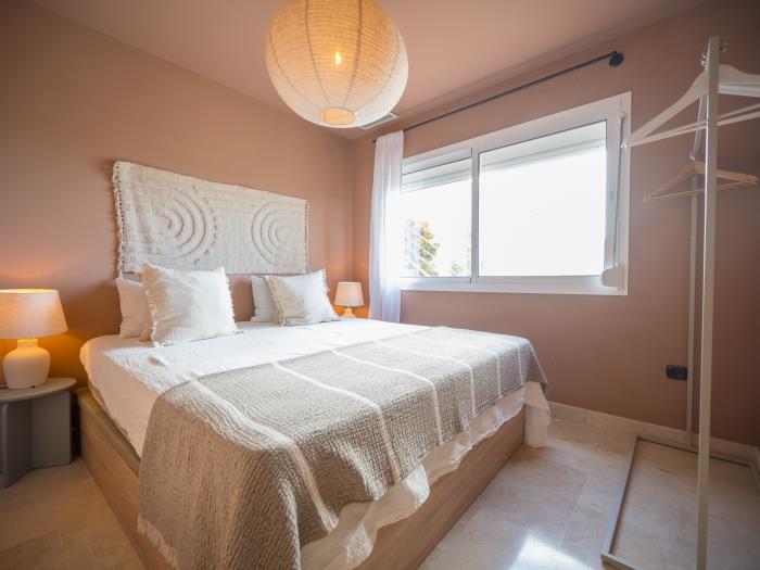 Double bed, nightstands and lamps with shade in bedroom