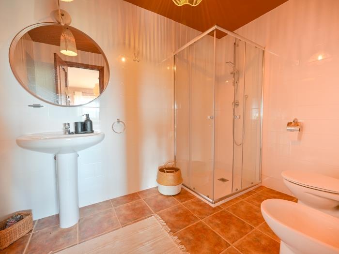 En suite bathroom with walk in shower, bidet, toilet and sink with mirror