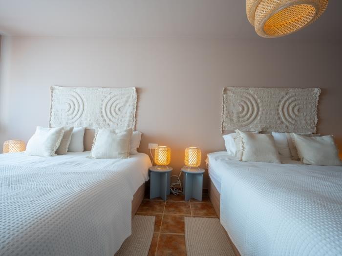 Bedroom with two double beds, wardrobe abd en suite bathroom