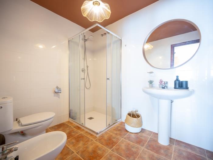 En suite bathroom with walk in shower, bidet, toilet, sink with mirror